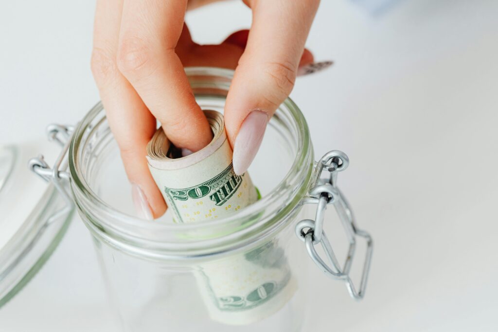 Putting money in a jar for saving. 
